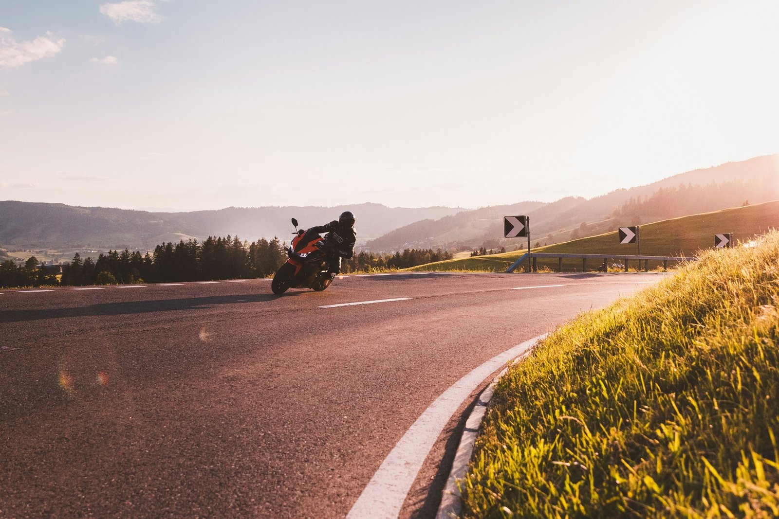Motorradfahrer auf einer freien Landstraße bei Sonnenschein